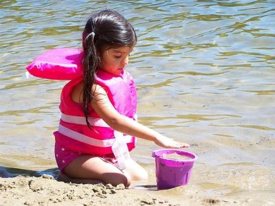 Schwimmwesten für Kinder - Kind mit Schwimmweste am Strand